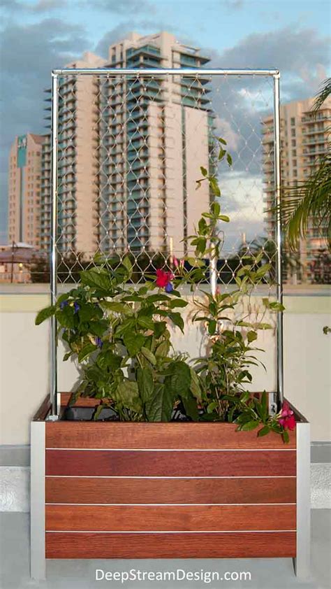 Hardwood and mesh trellis with planter boxes .